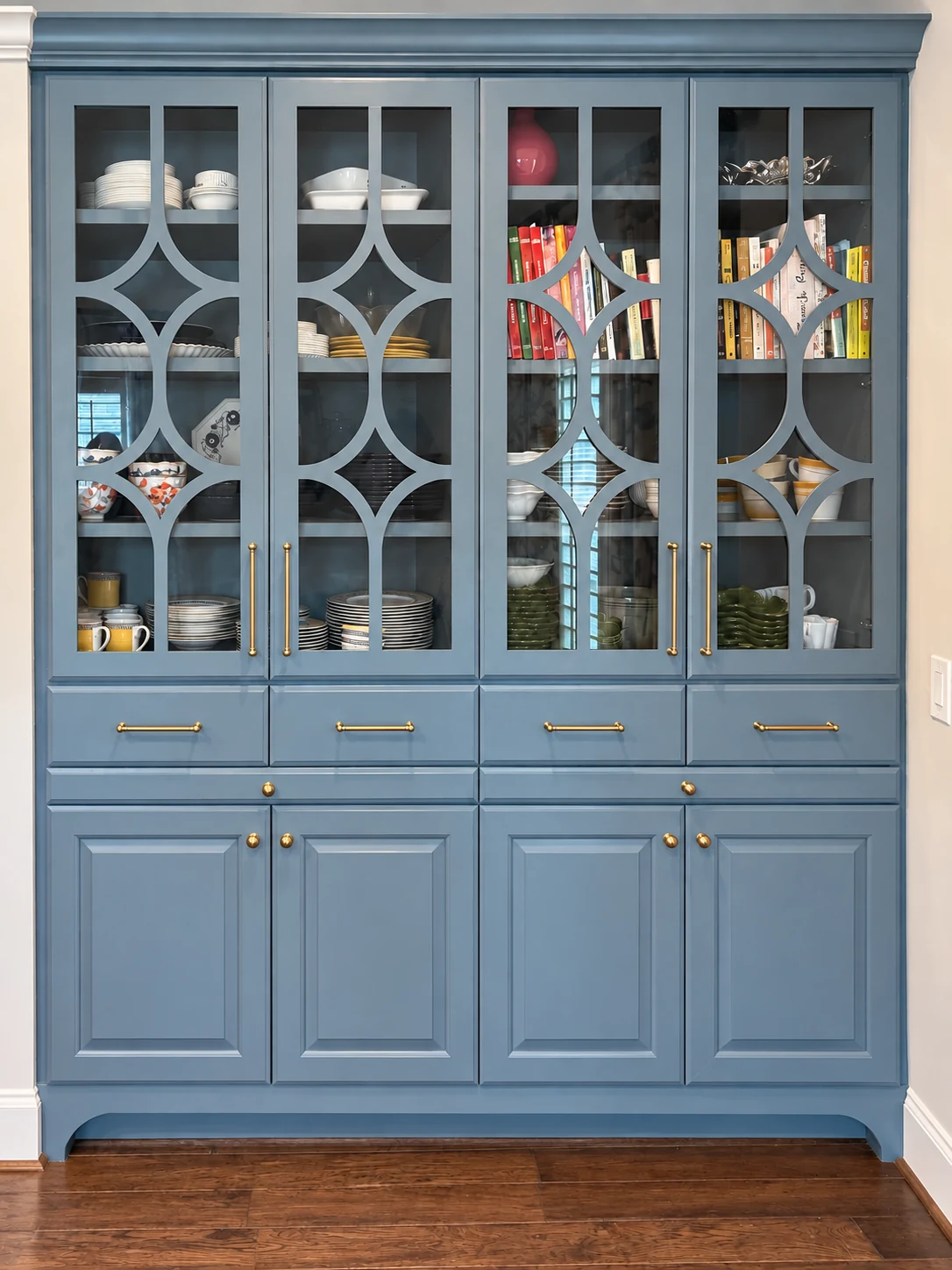Blue glass-front built-in cabinet with closed lower doors and drawers